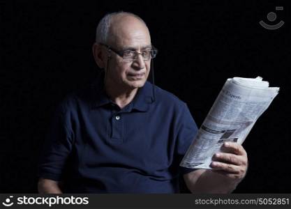 Old man reading newspaper