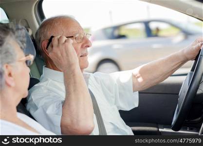 old man using mobile phone while driving