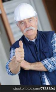 old man with a helmet thumbs up