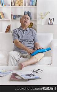 Old man with hot water bag on leg