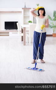 Old mature woman tired after house chores