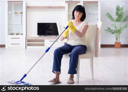 Old mature woman tired after house chores