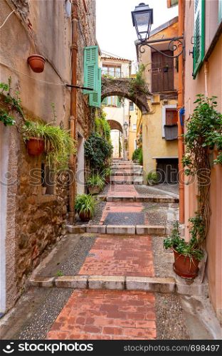 Old medieval narrow street in the historical part of the city. Menton. France. Cote d'Azur.. Menton. Old narrow street in the historic part of the city.