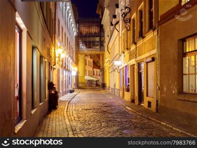 Old medieval street in the historic center of Riga at night.. Riga. Old street at night.