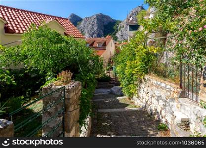 Old medieval street in the historical part of the city on a sunny day. Omis. Croatia.. Old street in Omis city on a sunny day.