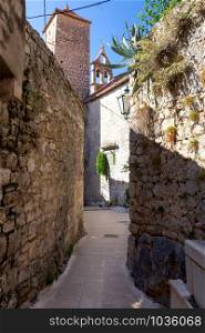 Old medieval street in the historical part of the city on a sunny day. Omis. Croatia.. Old street in Omis city on a sunny day.