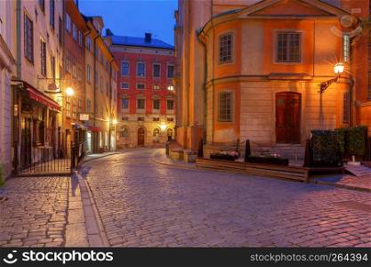 Old medieval street in the night illumination on the island Gamla Stan. Stockholm. Sweden.. Stockholm. Old street at night.