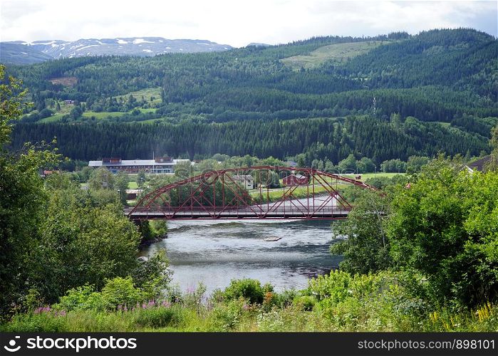 Old metal arch bridge and river in Norway