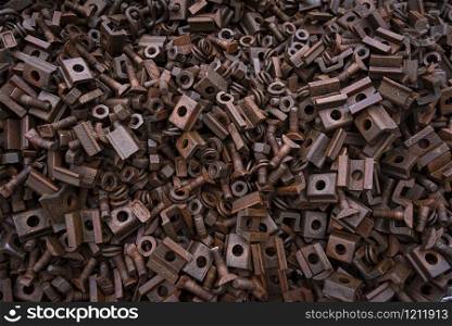 Old metal collected for recycling. Pile of rusty iron screws and screw nuts from old railways. Huge pile of old metal pieces
