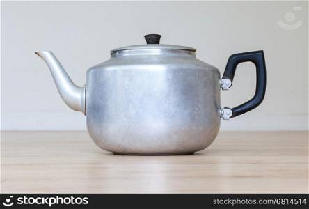Old metal tea pot isolated on wooden table