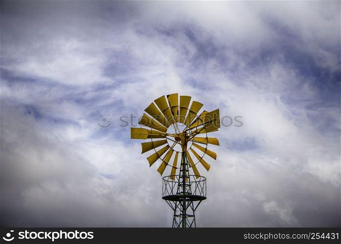 Old metal windmill in a field, detail of heolic energy