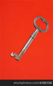 Old metallic key on red background