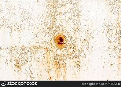 Old metallic white surface with a rusty spot in the center and a multitude of cracks. Background, texture.