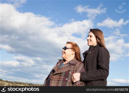 Old mother with sunglasses and her adult daughter at outside