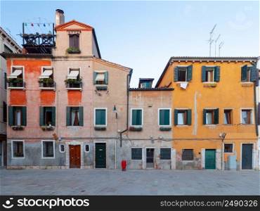Old multi-storey traditional Venetian houses in the town square. Venice. Italy.. Venice. Old traditional multi-colored stone houses in the historical part of the city.