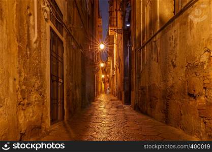 Old narrow medieval street in the light of lanterns. Palermo. Sicily. Italy.. Palermo. Old medieval street in night lighting.
