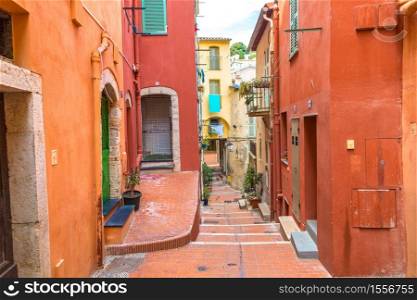 Old narrow street in Menton on french Riviera in a beautiful summer day, France