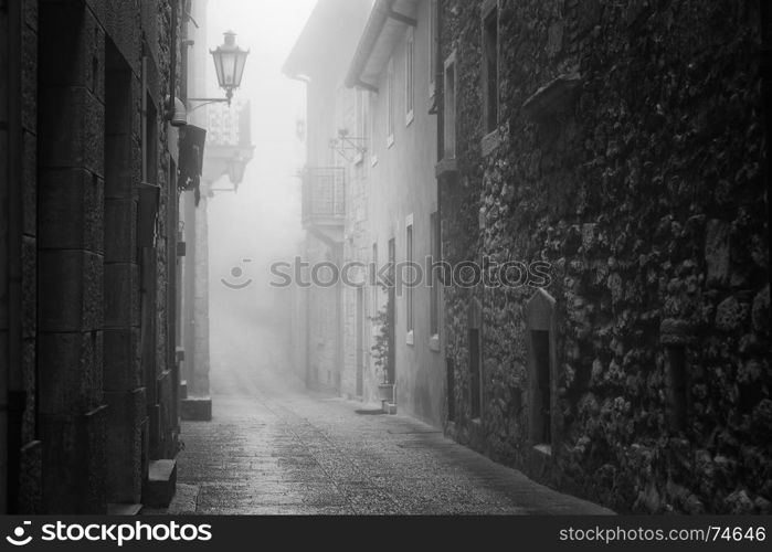 Old narrow street of San Marino during foggy weather