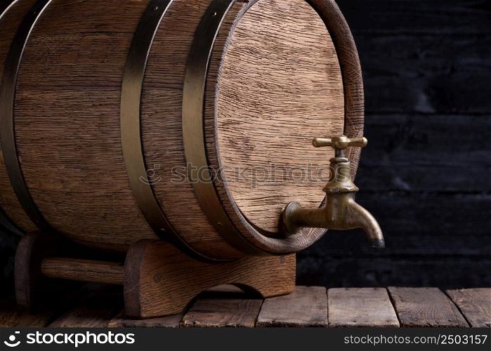 Old oak barrel on rack on grunge wooden table still life