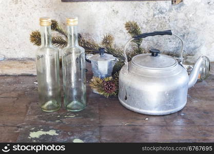 Old objects on a table to kitchen: kettle, coffepot and two bottles