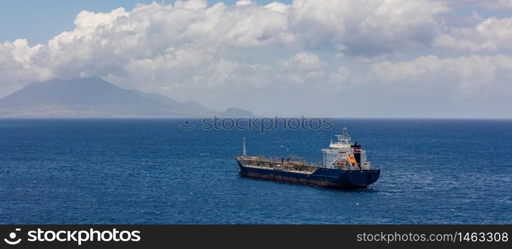 Old oil tanker moving towards St. Eustatius island in the Caribbean. Single life boat in the back of the ship