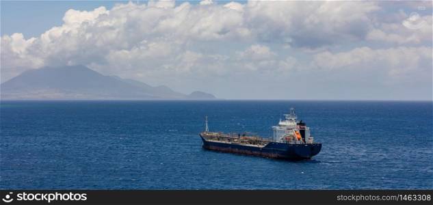 Old oil tanker moving towards St. Eustatius island in the Caribbean. Single life boat in the back of the ship