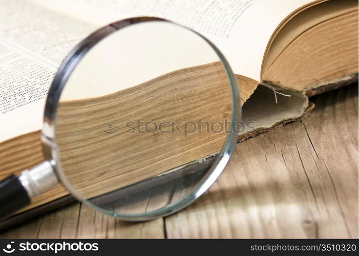 old open book and magnifying glass