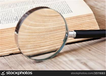 old open book and magnifying glass