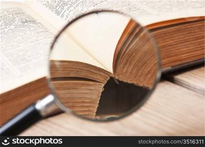 old open book and magnifying glass