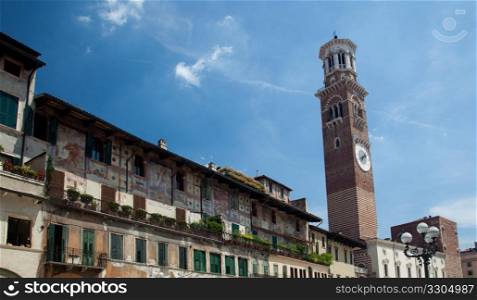 Old painted buildings in Erbe square in Verona with Lamberti Tower