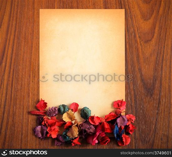 old paper with dry flower on wooden background