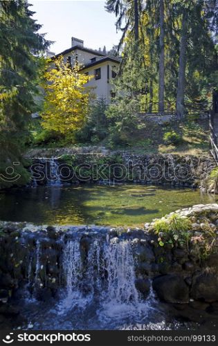 Old park Tsarska or Royal Bistritsa with terraced river, waterfall and differently trees in the venerable autumnal forest near by resort Borovets, Rila mountain, Bulgaria