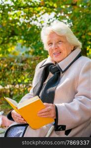 old pensioner reading a book in the park
