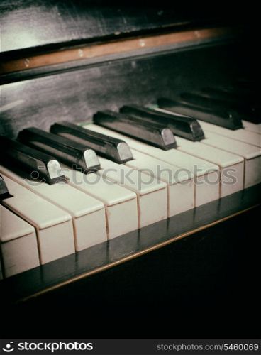 Old piano keyboard close up as a music background. With dust and scratches paper texture