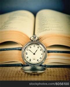 Old pocket watch and an open book