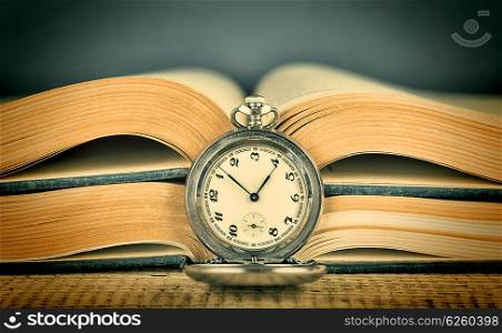 Old pocket watch and an open book, Toned