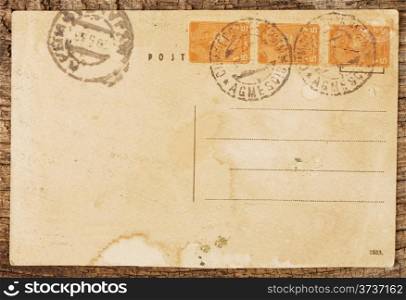 Old postcard on the rough wooden background