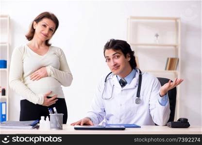 Old pregnant woman visiting young male doctor 