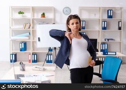 Old pregnant woman working in the office 