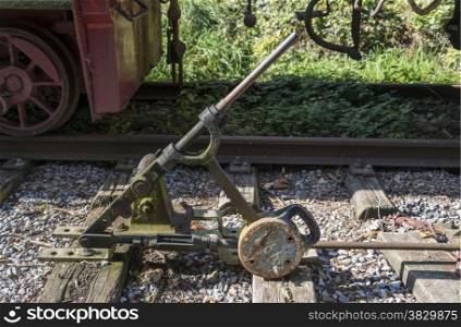 Old railroad track switch with train background