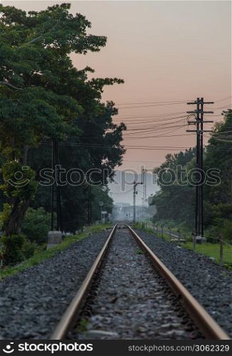 Old railroad train tracks in the countryside against beautiful sky in nature. Transport and shipping landscape concept. Selective focus.