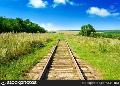 Old railway track among summer fields.