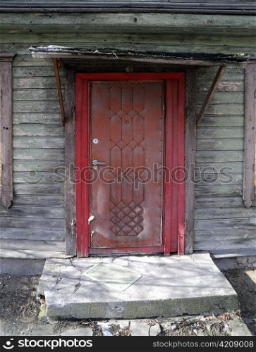 Old red door. Wooden residential house. Gypsy construction