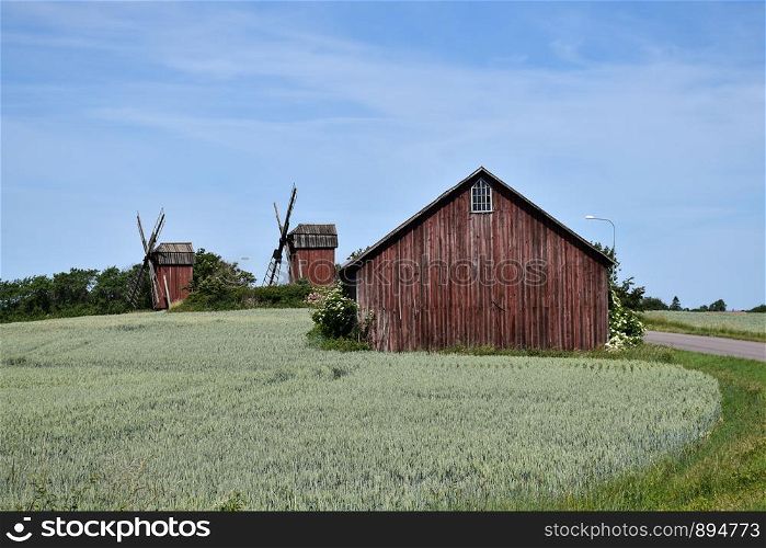 Old red windmills and a red barn in a farmland at the swedish island Oland, the island of sun and wind