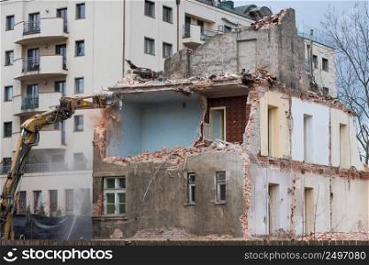 Old residential three story building demolition with excavator