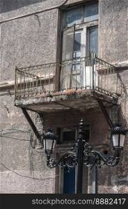 Old retro balcony of aged weathered house facade closeup