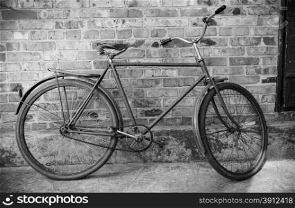 Old retro bicycle against brick wal, bw photol