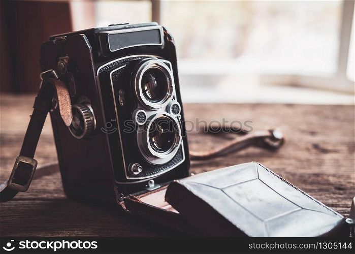 Old retro camera on old wooden background
