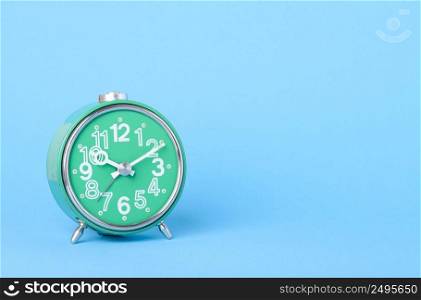 Old retro clock on blue background with copy-space