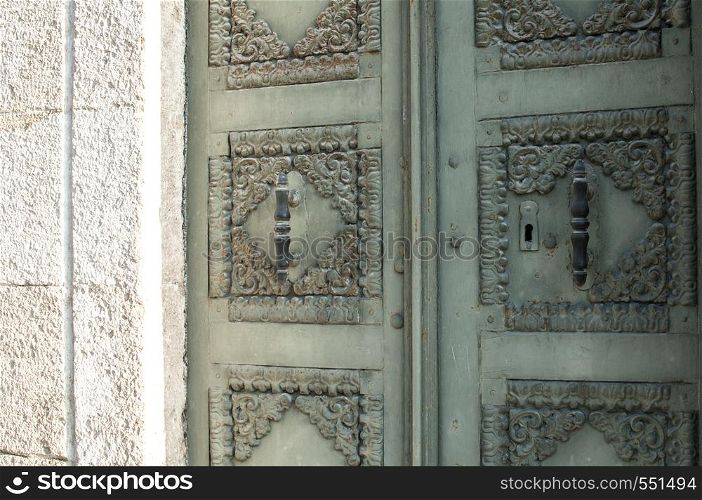Old retro iron house front door on stone wall facade